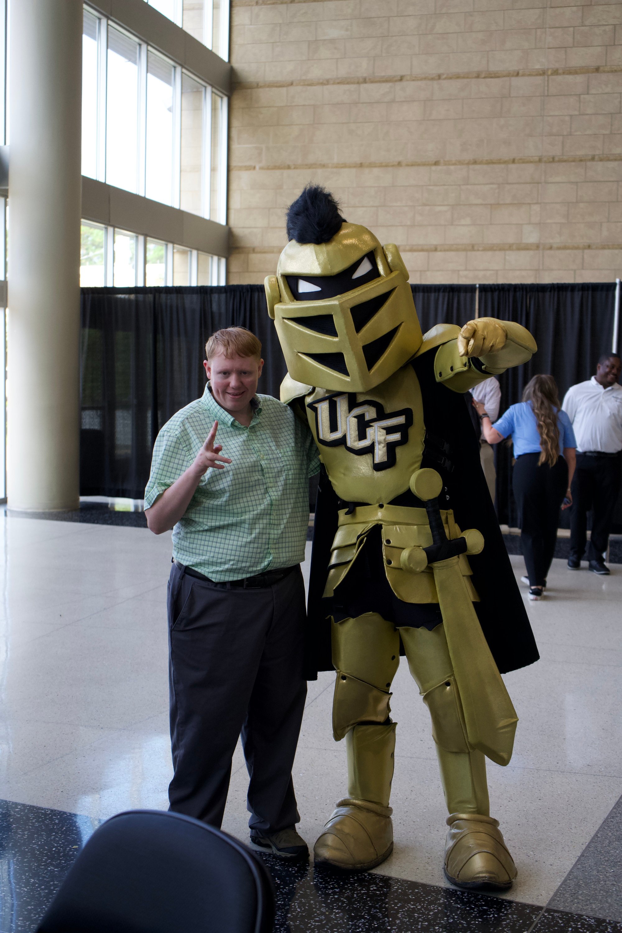 Knightro taking picture with attendee. 